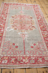 Vintage distressed Oushak rug, abrashed slate field with pale blush florals and wear.