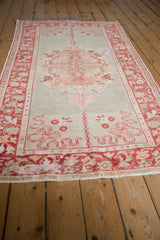 Distressed vintage Oushak rug fringe with worn texture and time-softened red tones.
