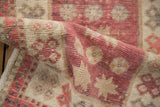 Vintage Distressed Oushak rug's worn pile texture, with raspberry red and beige floral motifs.
