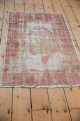 Vintage distressed Oushak corner, wide main border, ribboned vine motif, dusty rose.