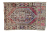 Distressed Vintage Oushak rug with stepped medallion and geometric florals in faded violet, rose, and sand.