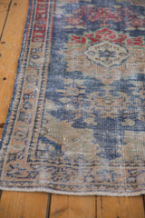 Distressed vintage Oushak rug side border with faded navy blue, beige, and cherry red patterns.
