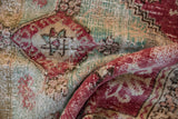 Textured close-up of vintage Oushak rug showing worn pale raspberry and mint floral designs.