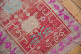 Textural detail of vintage Oushak rug with fuchsia floral designs, faded red, and abrashed surface.