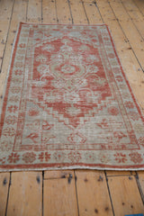 Distressed vintage Oushak rug featuring pale madder red, beige finned blossom motifs and stepped outlines.