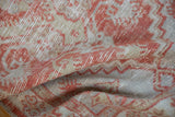 Textured pile of distressed Oushak rug with madder red and beige geometric motifs.