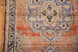 Distressed hand-knotted Oushak rug texture, showing worn knot heads and faded colors.