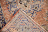 Distressed pile texture and visible side selvage of a Vintage Oushak rug.