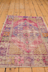 Distressed pink, purple, saffron Oushak rug with geometric floral cross-sections.
