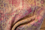 Distressed vintage Oushak rug pile featuring vivid pink, purple, and saffron yellow.