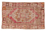 Distressed Oushak rug with oversized floral medallion, serpent designs, and faded plum, blue, orange tones.
