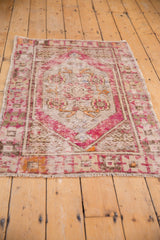 Vintage Oushak rug: textured plum border and ivory field, showcasing mostly even distressed wear.