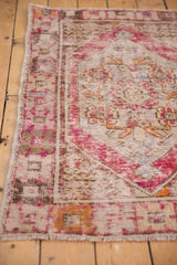 Vintage distressed Oushak rug, plum and tangerine floral border, showing knot head wear.