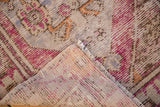 Vintage Distressed Oushak rug corner showing worn pile, exposed foundation, and original selvage.