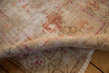 Distressed Oushak rug's hand-knotted texture with beige, sand, and dusty blush tones.