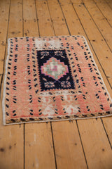 Distressed vintage Oushak rug corner with worn pile and leopard pattern border.