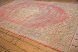 Worn texture of a distressed vintage Oushak rug with blush, ivory, and seafoam green.