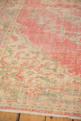 Worn pile texture of distressed Oushak rug in blush, ivory, and seafoam green.