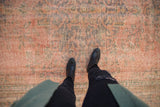 Distressed vintage Turkish Oushak carpet with dusty blush and muted ornamental patterns.
