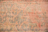 Distressed Oushak carpet's low pile texture, revealing dusty blush, green, and denim blue tones.