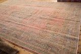 Distressed Oushak carpet detail: faded blush, denim blue, gold floral motifs, low pile.