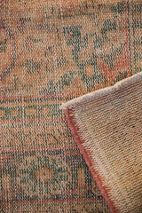 Distressed Oushak carpet texture with visible foundation and soft blush side cord selvage.