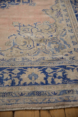 Distressed texture and cobalt blue curvilinear border on a vintage Oushak rug.