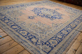 Distressed texture, worn fringe, and secured selvage of the hand knotted Oushak rug.