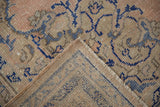 Distressed pile of a vintage Oushak rug, featuring blue patterns and its hand-knotted reverse.