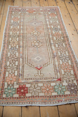 Close-up of distressed Oushak rug runner border, revealing floral top views and even wear.