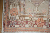 Distressed vintage Oushak runner corner with wide banded floral border and pale tangerine accents.