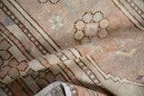 Hand knotted distressed Oushak rug runner showing muted floral motifs, even wear, and soft beige hues.