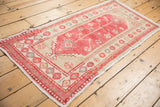 Distressed Oushak runner from a perspective angle, with faded raspberry plant motifs and even wear.