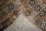 Distressed Oushak pile showing wear with blue patterns and woven ivory foundation.