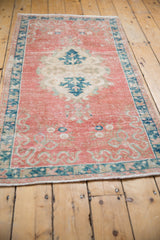 Distressed blush and navy Oushak runner showing ribboned vinery and mostly even wear.