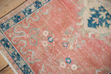Distressed Oushak rug with blush field, navy blue geometric border, and visible even wear.