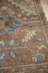 Distressed vintage Oushak rug pile with even height, denim blue, and coffee brown geometric motifs.