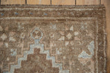 Distressed vintage Oushak rug with even pile, showing coffee brown and denim blue patterns.