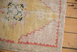 Distressed Oushak rug texture: low pile, dusty gold, pale brick red, and dark blue geometric motif.