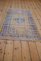 Detail of vintage distressed Oushak rug border, showing mostly even wear and dusty navy blue tones.