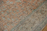 Distressed vintage Oushak carpet texture with worn pile, pale terra cotta, and ivory details.