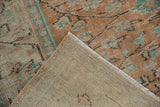 Distressed vintage Oushak pile in pale terra cotta, ivory, teal, with exposed hand-knotted foundation.