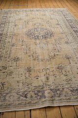 Distressed Oushak rug border with faded blue floral design and even wear to knot heads.