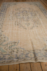Worn antique ivory pile and soft blue-green patterns on this distressed Oushak rug.