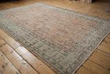 Distressed Oushak rug corner, worn knot heads, pale terracotta, ivory border, vinery.