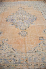 Vintage Distressed Oushak Carpet showing worn apricot field and faded blue medallion detail.