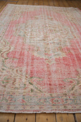 Distressed vintage Oushak carpet with wear to foundation, faded blush and ivory tones.