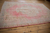 Intact side selvage of the distressed Oushak rug, showing faded Rococo border pattern.
