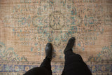 Distressed vintage Oushak rug's worn pile texture with faded beige, blue, mint floral design.