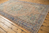 Side border and distressed field of vintage Oushak rug with royal blue, apricot, mint florals.